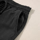 Close-up of the drawstring waist and pockets of Bella Road Black Wide Leg Jeans on a light background.