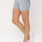 Woman wearing Judy Blue Color Block Denim Shorts with white sneakers, showcasing the trendy summer fashion with playful contrasting colors.