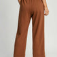 Back view of Umgee drawstring wide leg pants in brown, showcasing adjustable waist and relaxed silhouette.