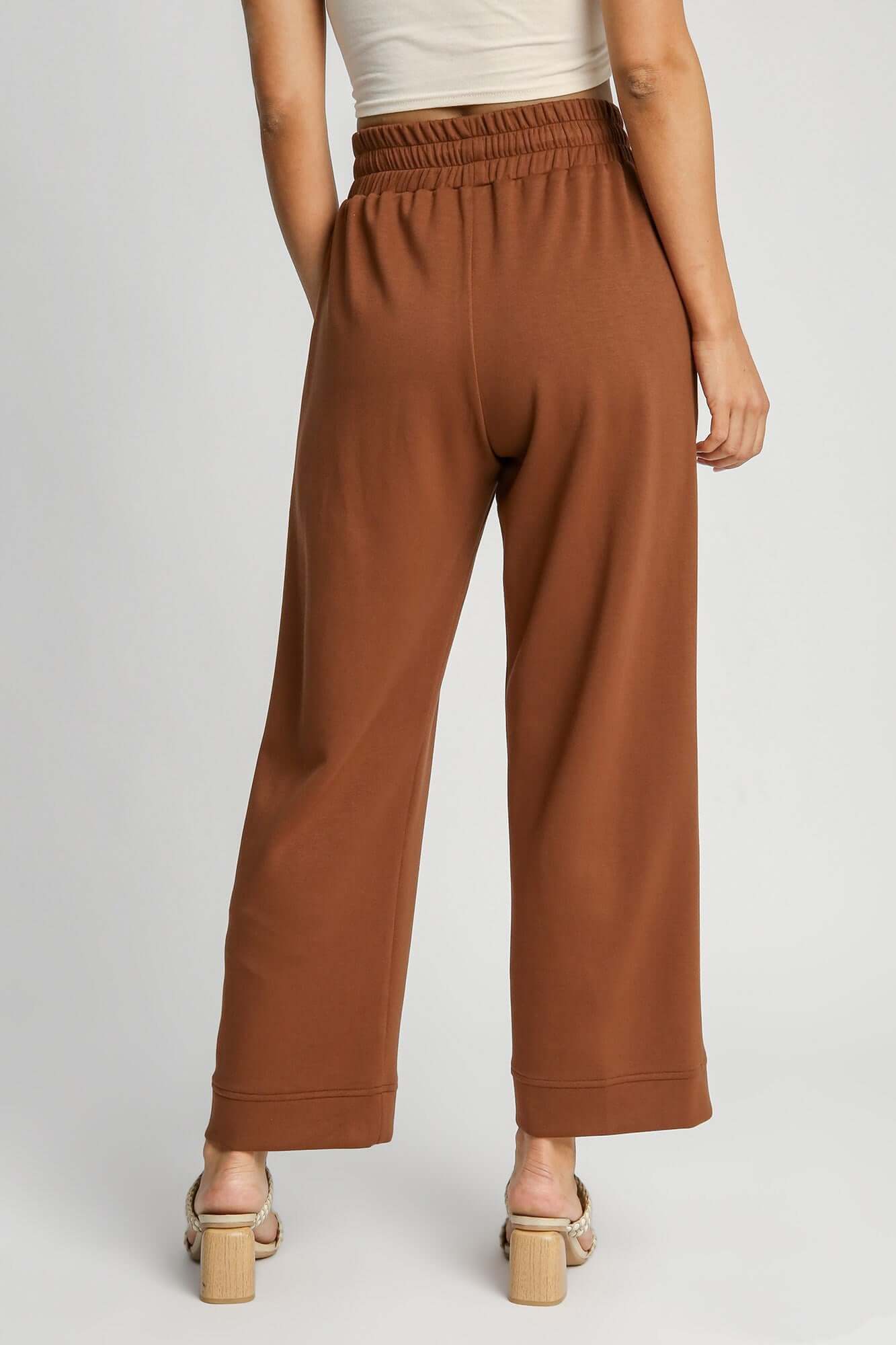 Back view of Umgee drawstring wide leg pants in brown, showcasing adjustable waist and relaxed silhouette.