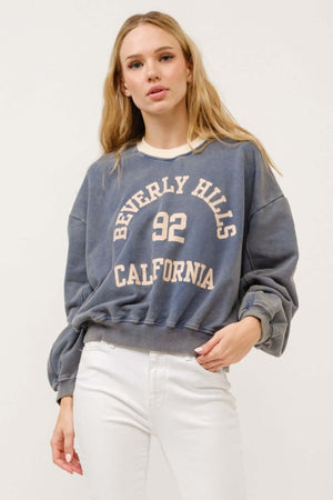 Woman wearing Beverly Hills 92 California contrast crop sweatshirt with bold graphic design and casual vibe.