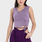 Woman wearing Millennia Drawstring Ruched Wide Strap Active Tank in lavender, paired with stylish purple leggings.