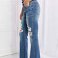 Risen Jeans Hazel High Rise Distressed Flare Jeans with frayed hem, worn by model in pink top. Long and stretchy rock style denim.