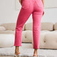 Woman wearing Crop Dylan full size tummy control high waist raw hem jeans in pink by RFM Jeans, showcasing back view and slender leg line.