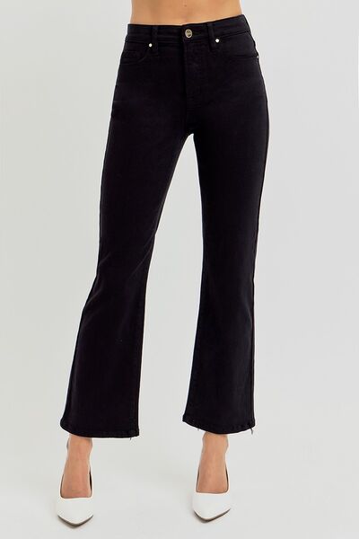 Woman wearing RISEN Full Size Tummy Control High Rise Crop Straight Jeans in black with white heels.