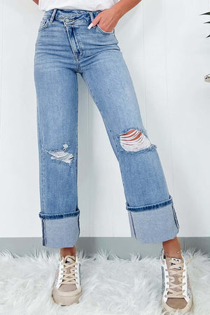 Distressed straight jeans with pockets, cuffed hems, and ripped details, slightly stretchy, perfect casual wear on a soft white rug.