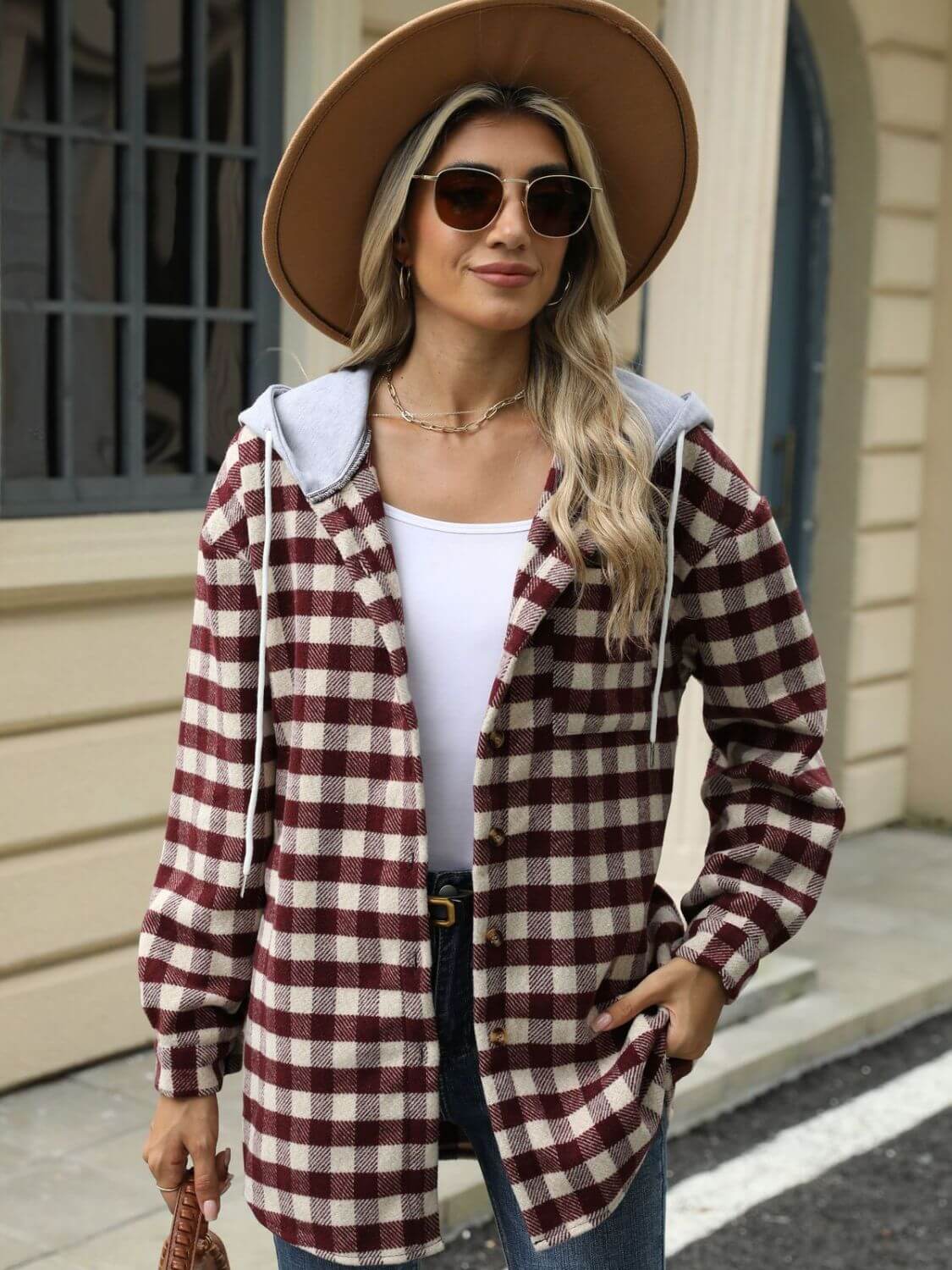 Woman wearing Bella Road Drawstring Plaid Long Sleeve Hooded Jacket, white top, and hat outdoors. Stylish fall fashion.