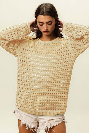 Woman wearing a Round Neck Openwork Knit Cover Up paired with white shorts, showcasing the stylish openwork knit design.