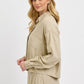 Stylish woman wearing a RISEN button down long sleeve shirt in beige, perfect for versatile occasions.