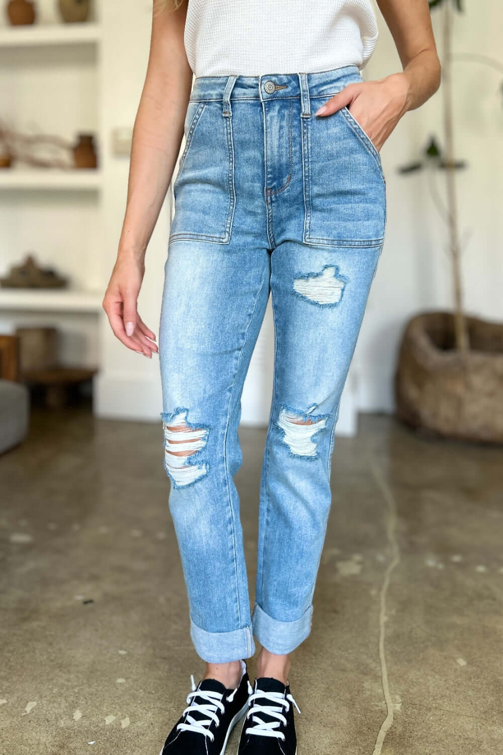 Woman wearing high-waisted distressed straight Judy Blue Jeans with patch pockets and stylish detailing for a casual-chic look.