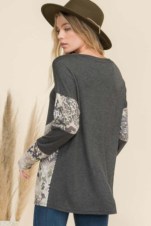 Woman wearing Celeste full-size mixed animal print contrast long sleeve T-shirt with a hat.