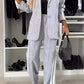 Stylish woman wearing gray denim two-piece set with contrast lapel collar, featuring a blazer and matching pants.