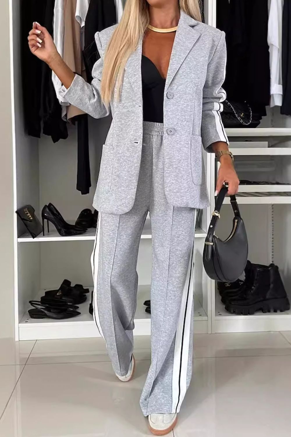 Stylish woman wearing gray denim two-piece set with contrast lapel collar, featuring a blazer and matching pants.