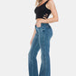 Woman wearing Judy Blue Full Size Tummy Control Cut Hem Flare Jeans with vintage wash and black top, showcasing a stylish silhouette