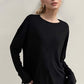 Woman wearing Basic Bae High-Low Long Sleeve T-Shirt in black, showcasing its relaxed style and slightly stretchy fabric.