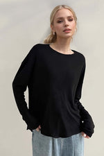 Woman wearing Basic Bae High-Low Long Sleeve T-Shirt in black, showcasing its relaxed style and slightly stretchy fabric.