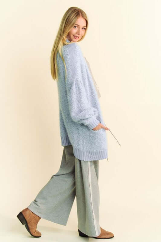 Stylish model showcasing a cozy light blue ribbed hem cardigan paired with trendy wide-leg pants. Perfect for any season!