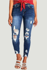 Distressed raw hem jeans with pockets and trendy design for women, perfect for a bold, edgy look.