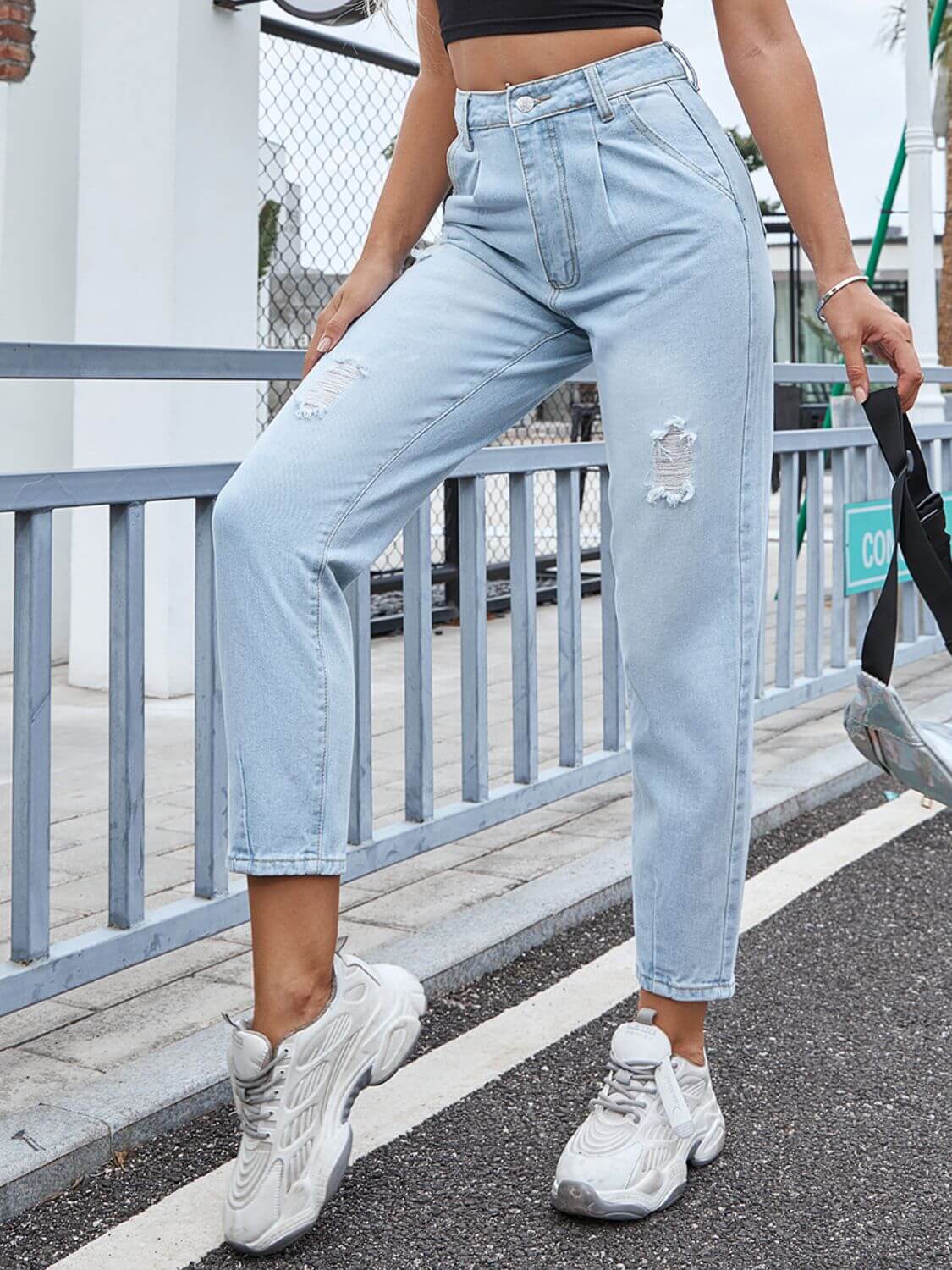 Woman wearing Bella Road Distressed Straight Jeans with Pockets, standing on a street in casual sneakers.