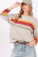 Woman wearing French Terry Color Block T-Shirt with 3/4 sleeves, reverse stitching fabric, floral contrast front, and multi-color detailing.