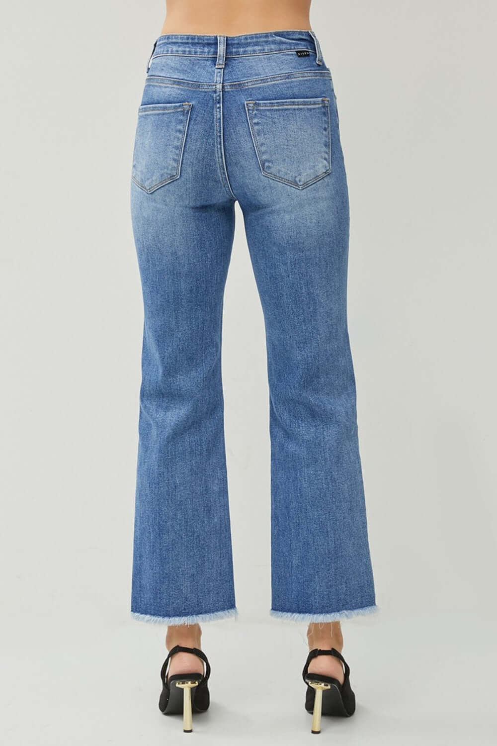 Back view of Risen Jeans' High Waist Raw Hem Slit Straight Jeans in blue denim, showcasing trendy raw hems and flattering fit.