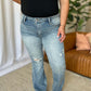 Woman wearing Judy Blue medium rise flare jeans with tummy control and distressed details for a stylish, comfortable look.