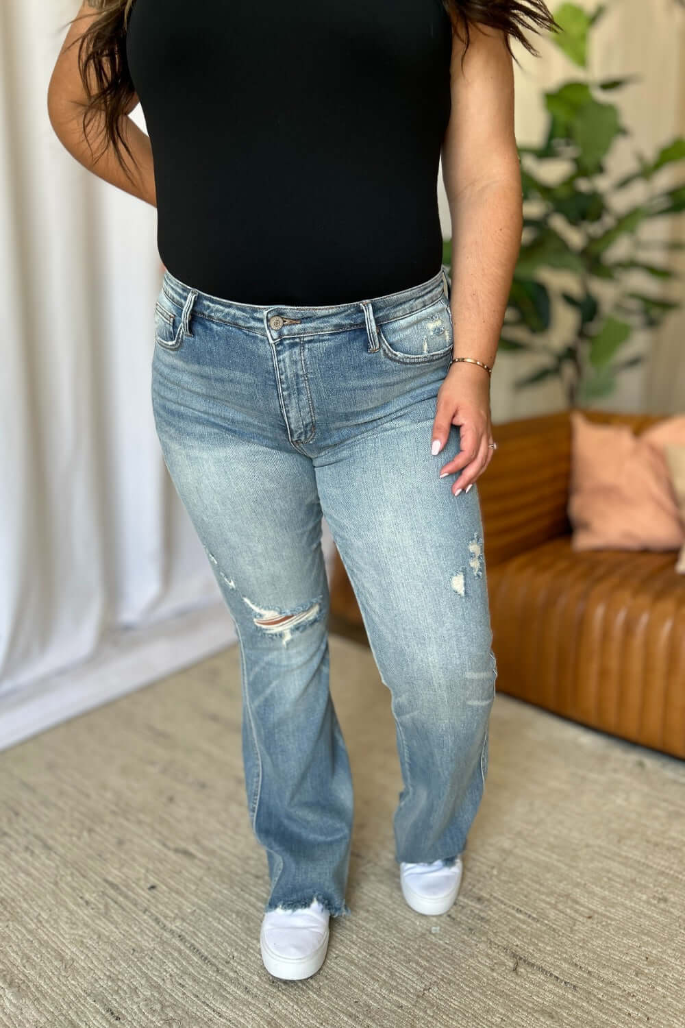 Woman wearing Judy Blue medium rise flare jeans with tummy control and distressed details for a stylish, comfortable look.