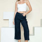 Woman wearing Judy Blue side seam braid detail crop wide leg jeans with a casual white top and heels.