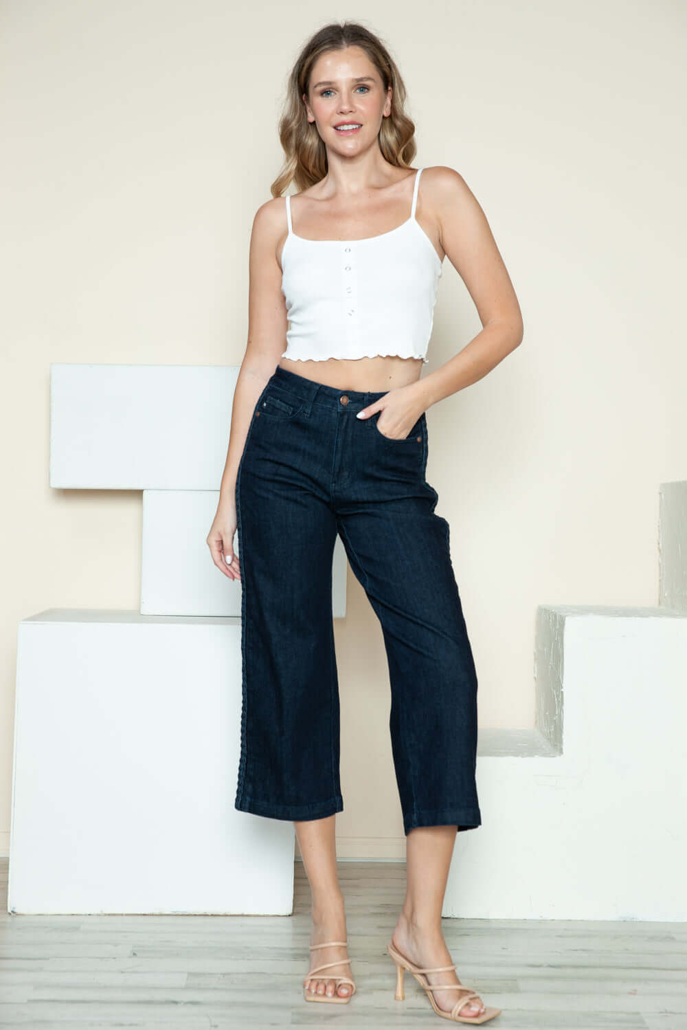 Woman wearing Judy Blue side seam braid detail crop wide leg jeans with a casual white top and heels.