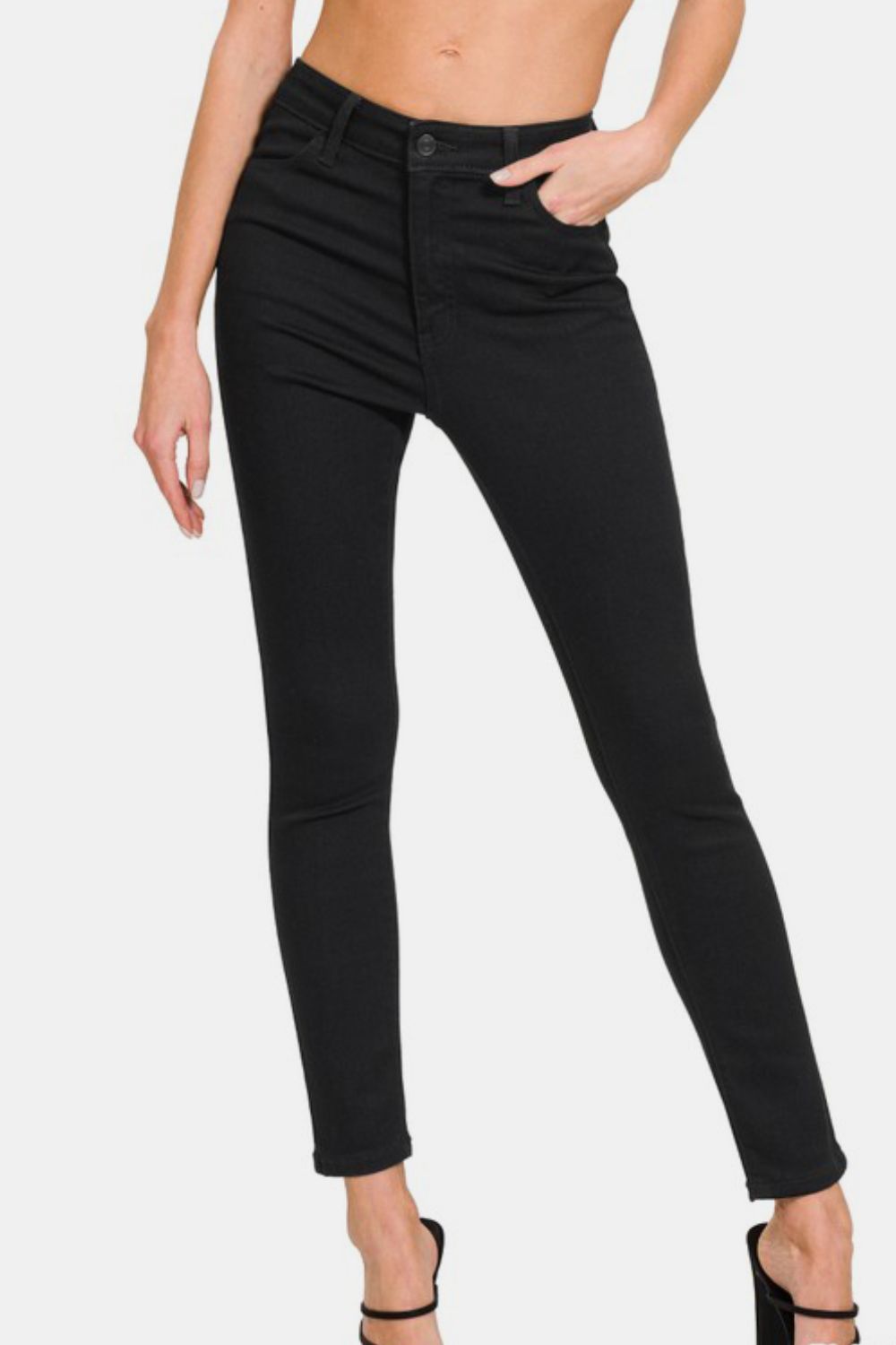 High rise skinny jeans in black, featuring functional pockets and a stylish slim fit for versatile fashion.