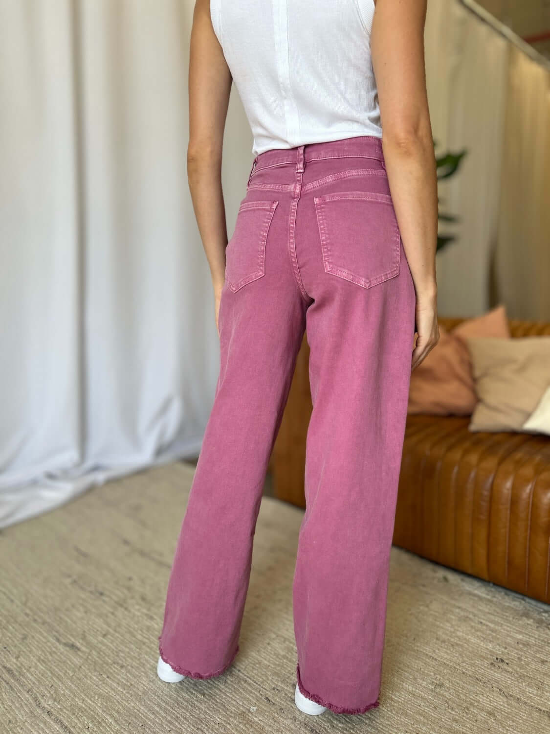 Woman wearing RFM Full Size High Rise Garment Dye Wide Leg Jeans in rich pink color, showcasing back view and relaxed silhouette.