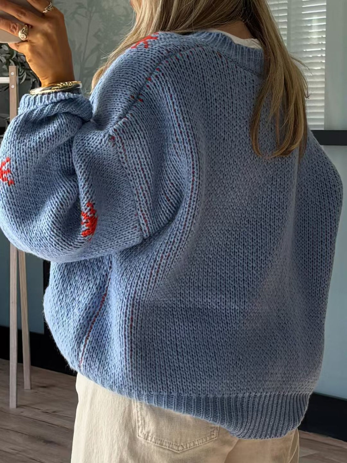 Cozy blue sweater with round neck and playful boot pattern, featuring dropped shoulders for relaxed style. Perfect for casual wear.