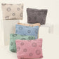 Five colorful corduroy clutch bags featuring playful smiley face prints, perfect for trendy casual outings.