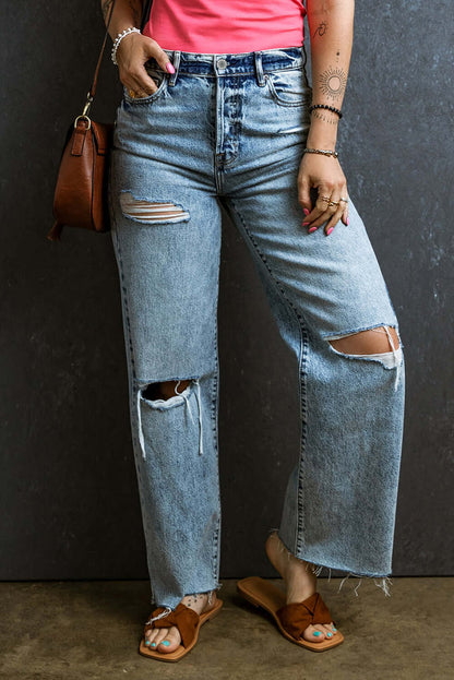 Petite distressed raw hem straight jeans with rips, modeled by a woman in a red top and brown sandals, trendy and edge style.