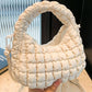 Quilted puffy crossbody bag with removable strap, elegant design in creamy white, perfect for versatile fashion styles.