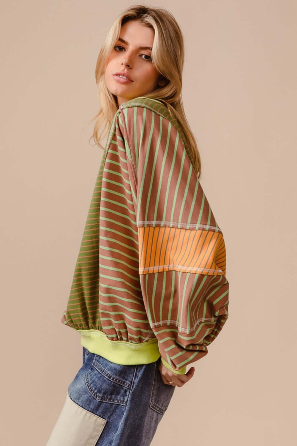 Stylish woman wearing a BiBi color block striped round neck sweatshirt in earthy tones, perfect for trendy casual outfits.