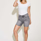 Woman wearing high waist washed denim shorts by Judy Blue Jeans, showcasing a retro-inspired look and feminine silhouette