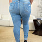 Woman wearing Judy Blue Mid Rise Destroy & Cuff Skinny Jeans, showcasing back view with destroyed detailing and cuffed hem.