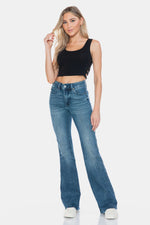 Woman wearing Judy Blue full-size tummy control cut hem flare jeans with vintage wash and modern design.