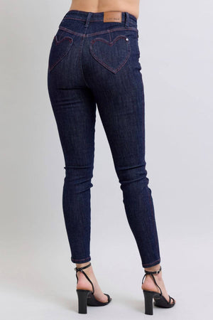 Heart-shaped back pocket skinny jeans in dark wash showcasing a flattering fit and stylish vibe for versatile wear.