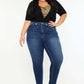 Stylish plus-size model in high-rise ankle skinny jeans with double waistband and trendy release hem.