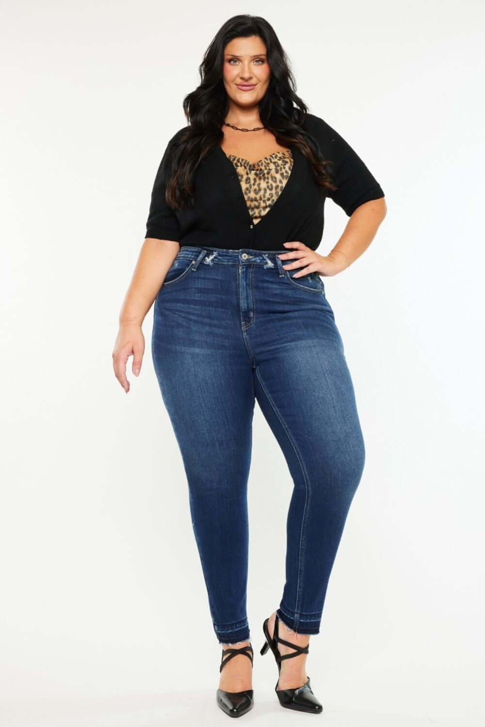 Stylish plus-size model in high-rise ankle skinny jeans with double waistband and trendy release hem.