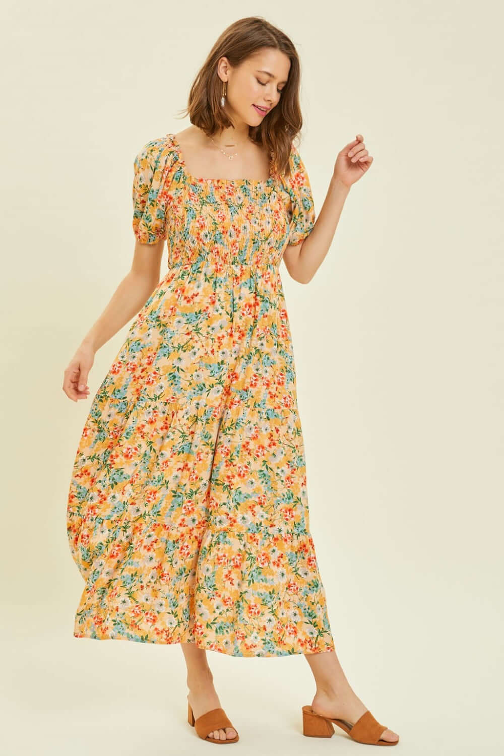 Woman wearing full size floral smocked tiered midi dress with a vibrant print and elegant design, perfect for summer occasions.