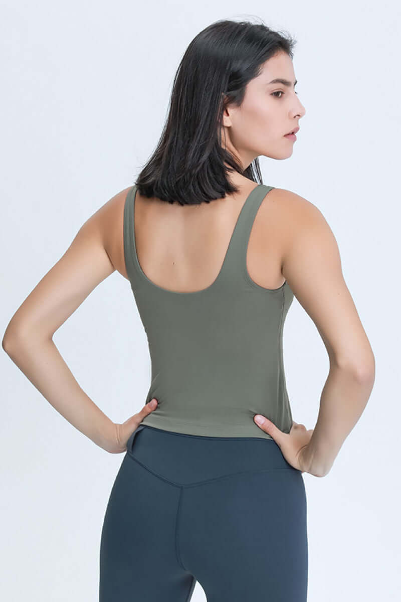 Model showcasing the back of a green Millennia V Neck Active Tank, perfect for stylish workouts and athleisure wear.