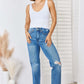 Woman wearing Judy Blue High Waist Distressed Straight-Leg Jeans with a white tank top and white shoes