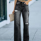 Woman wearing distressed straight leg jeans with no stretch in dark wash, holding a beige clutch purse outside.