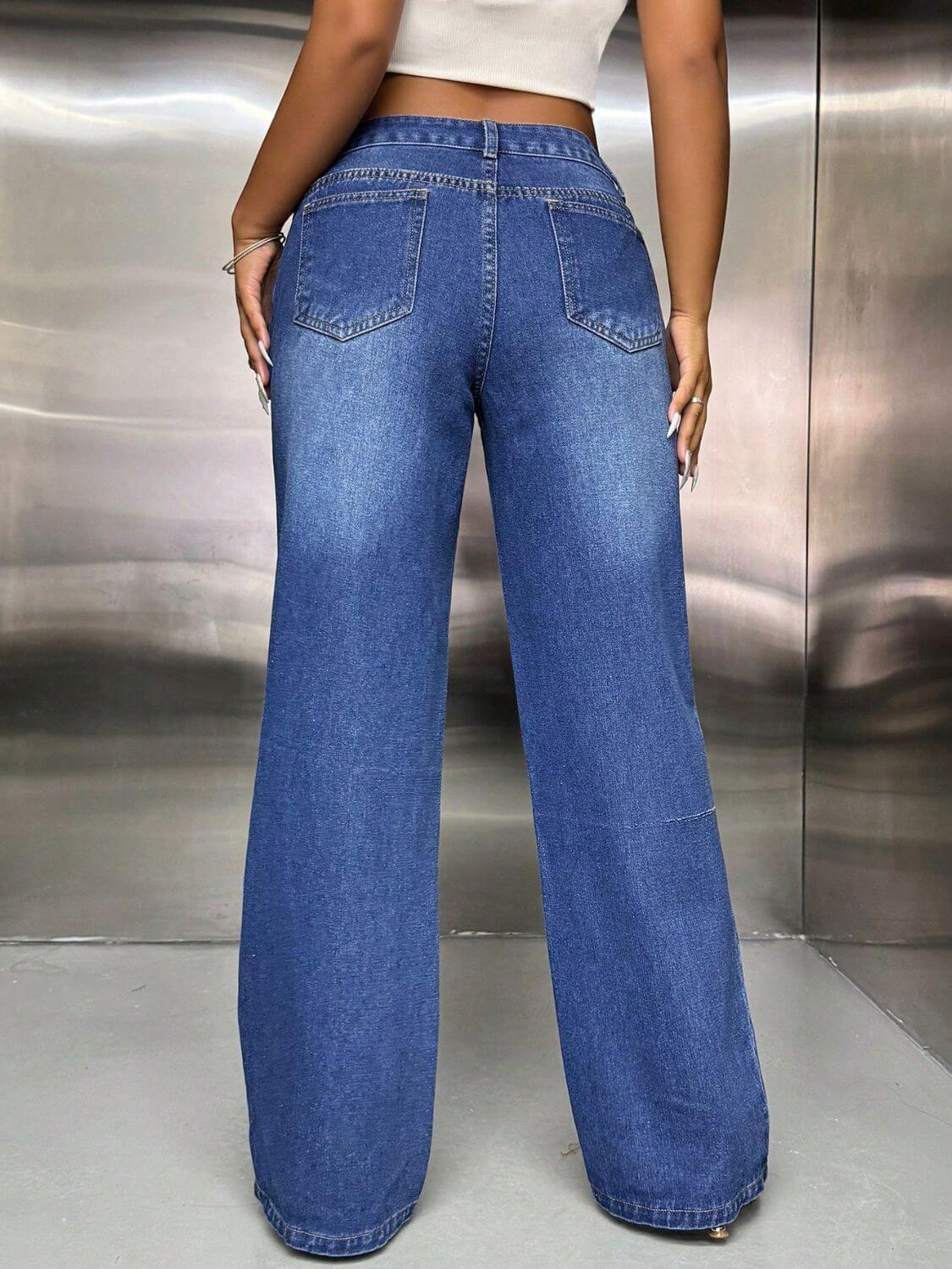 Woman wearing wide leg jeans with pockets, back view showing pocket design and fashion-forward style in blue denim.