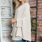 Woman wearing Bella Road Round Neck Batwing Sleeve Sweater in cozy setting