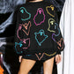 Woman in Bella Road Ghost Printed Round Neck Long Sleeve Top and Shorts Set, featuring multicolor ghosts on a black background.