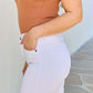 Woman wearing Alyssa High Rise Skinny Jeans in white, showcasing the snug and flexible fit and sleek silhouette.